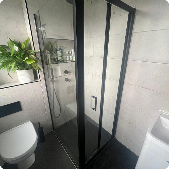 Modern walk-in shower with black framed shower screen